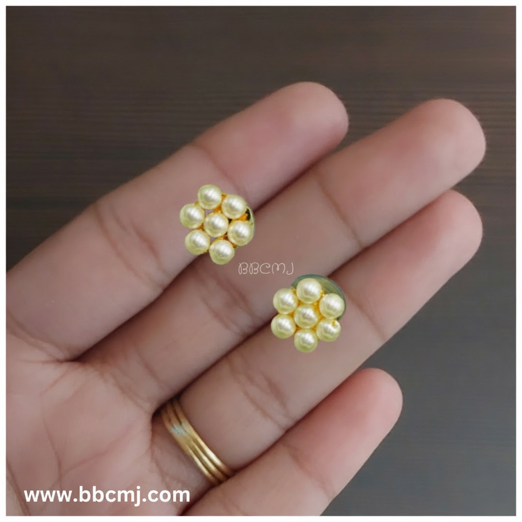 A pair of pearls earrings held between fingers, with a watermarked logo on the bottom right.