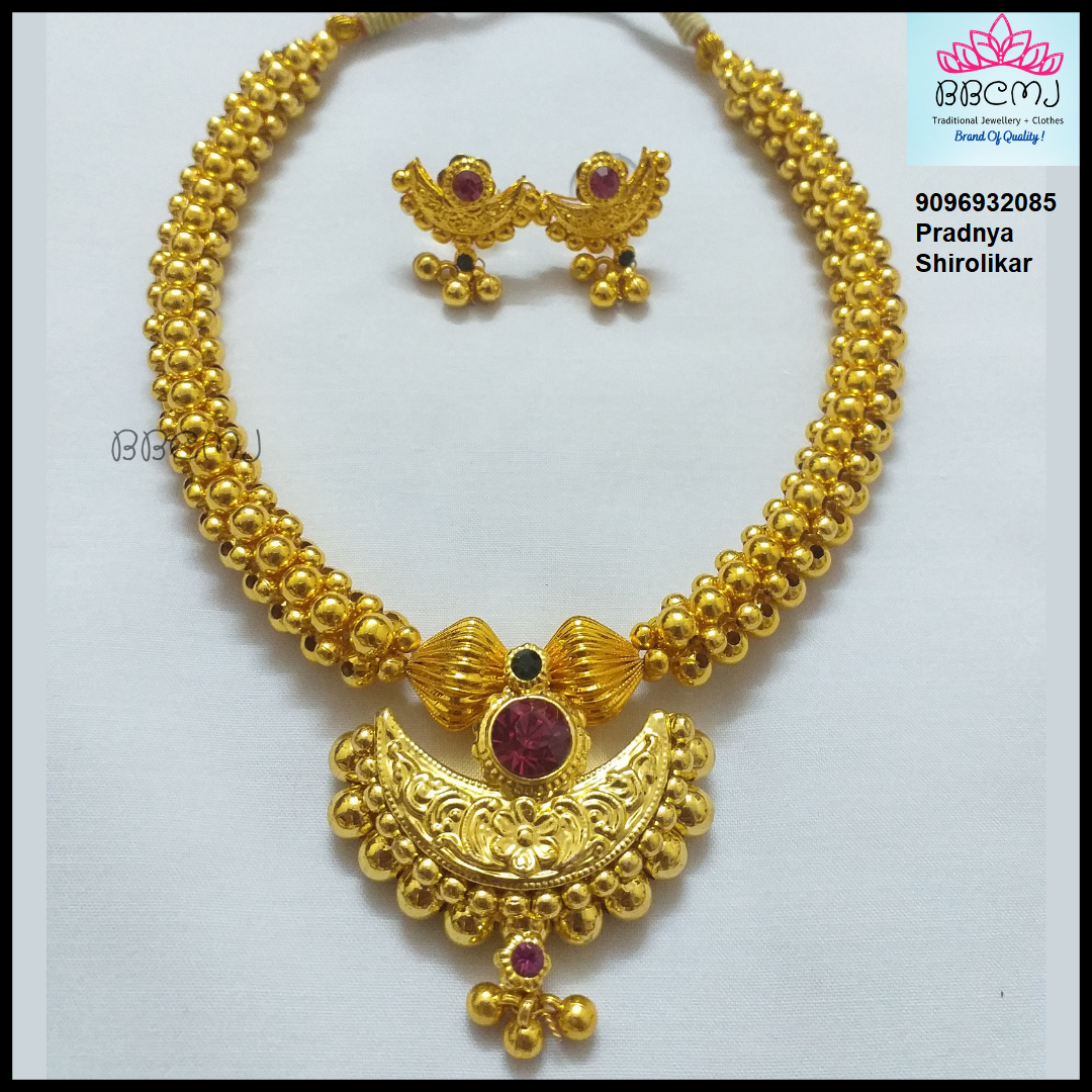 Gold necklace with matching earrings on a white background