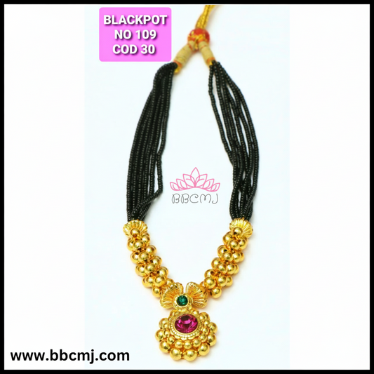 A gold coated black pot short mangalsutra with floral patterns and matching earrings, displayed against a white background.